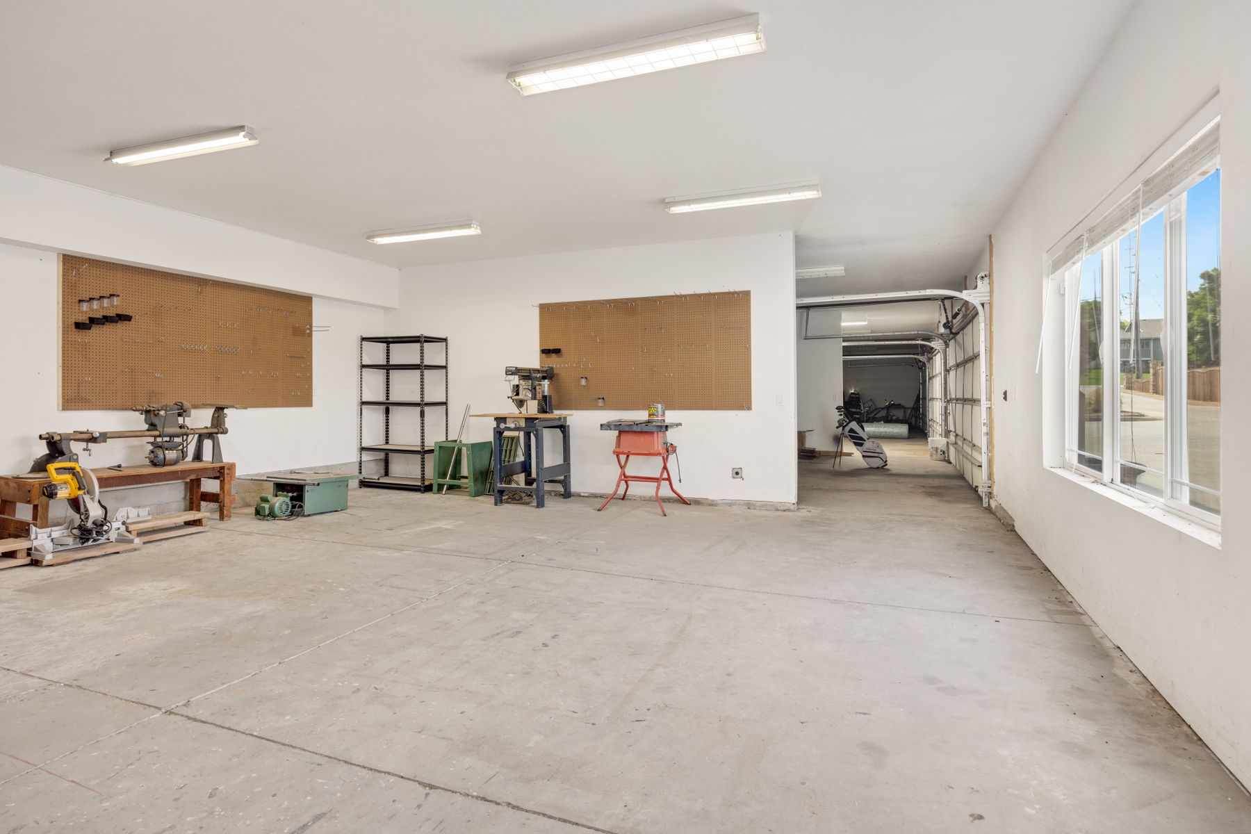 A cleared, swept garage with open shelving and clear floor space